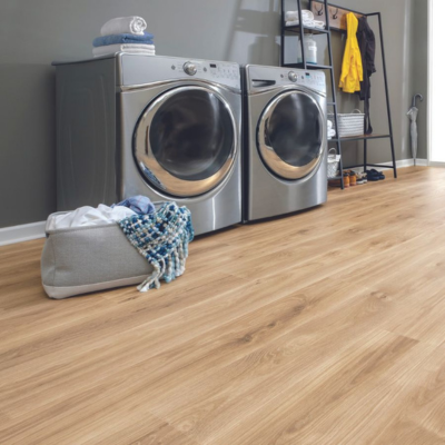 Modern laundry room with dark gray walls, stainless steel appliances, and light brown laminate flooring, complemented by organized shelving and a pop of yellow from a rain jacket.